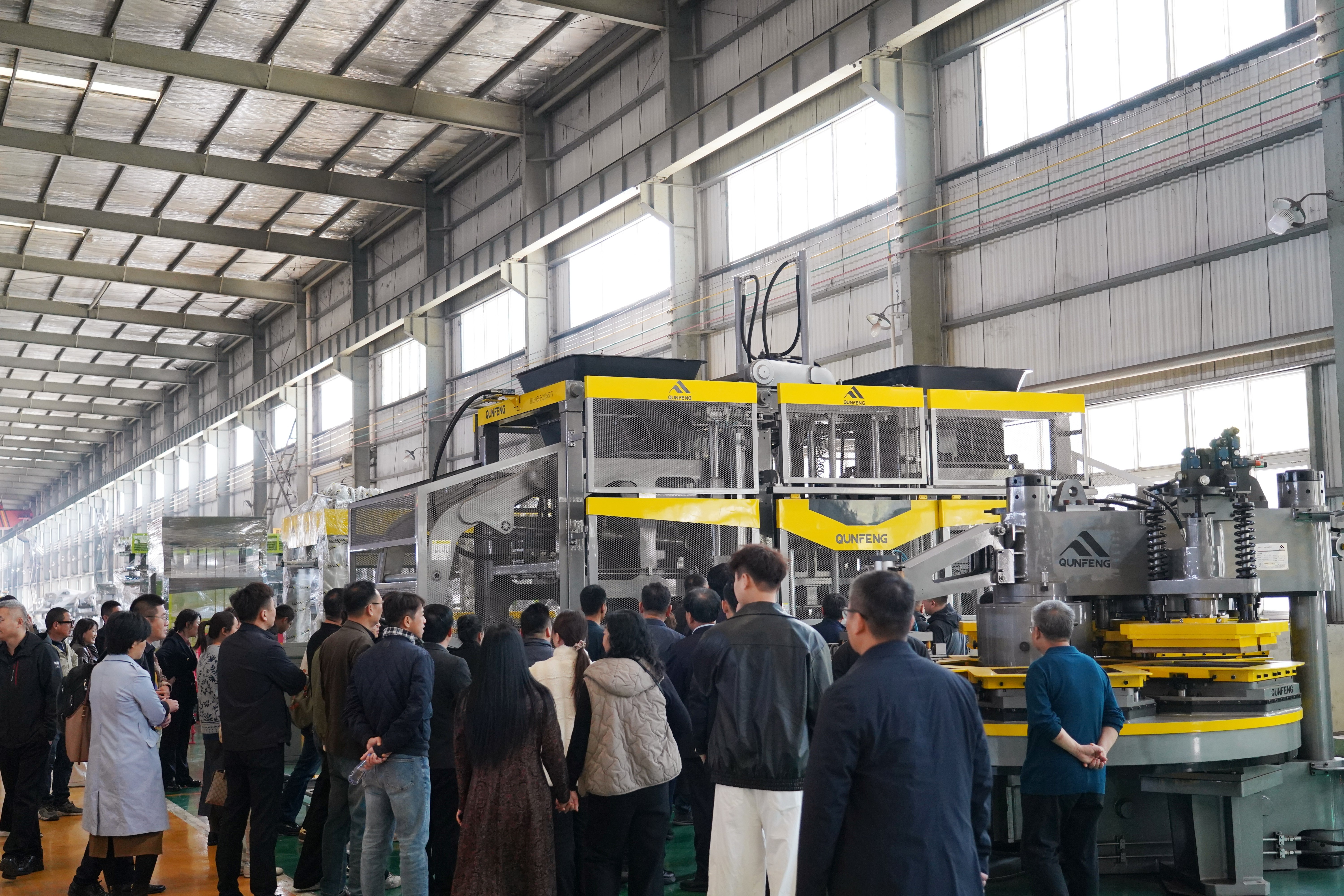 Industry leaders inspecting QS series concrete product molding machine at Qunfeng Equipment