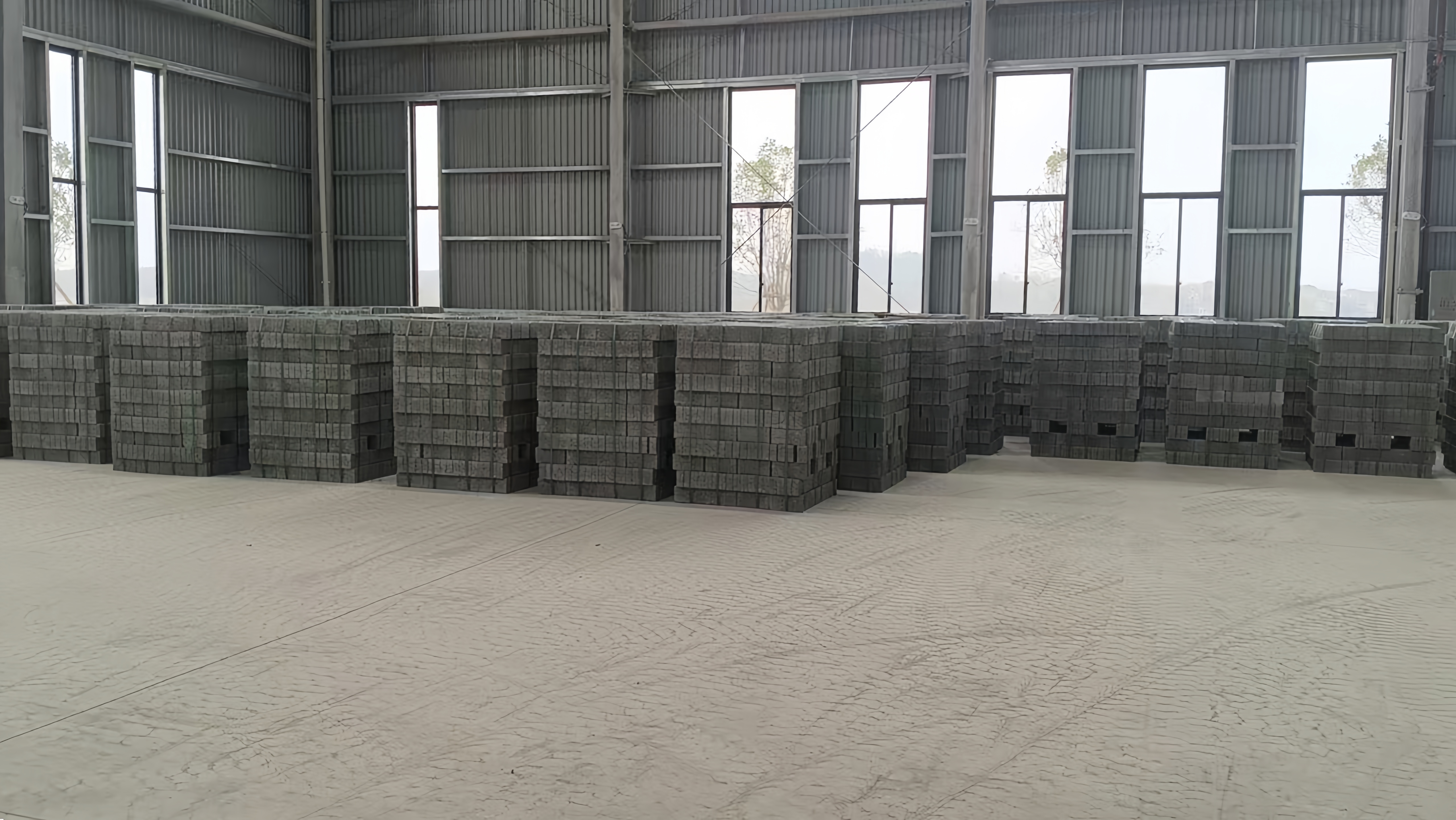 Products manufactured by the QS series concrete block machine, neatly stacked within the client’s workshop